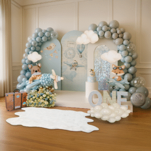 First Birthday balloon decor with 3 panels, a platform, a cake stand, ONE letters, and balloon sculptures in pastel blues and yellows. Balloon Decor.Oregon.