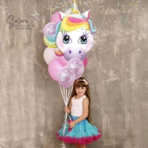 Little girl holding a large helium balloon bouquet with unicorn in pastel colors. Salem Oregon balloon delivery