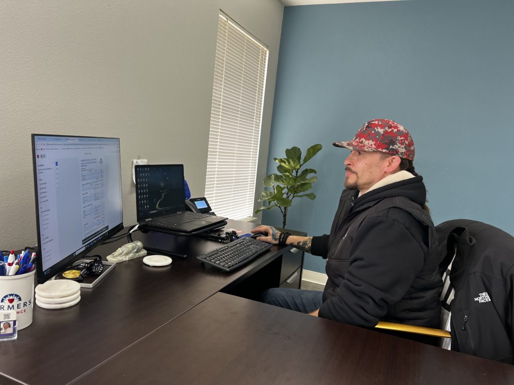 Mathew Poteet at his desk with computer - Poteet Agency - Farmer's Insurance