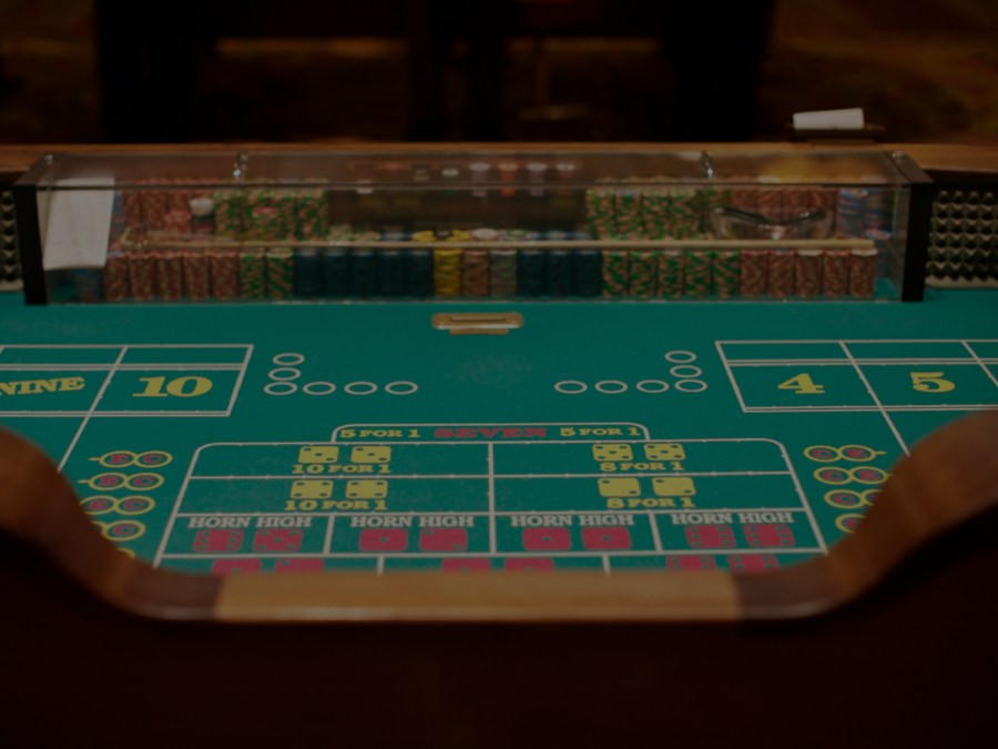 Image of casino table surface with multiple poker chips stacked in rows.