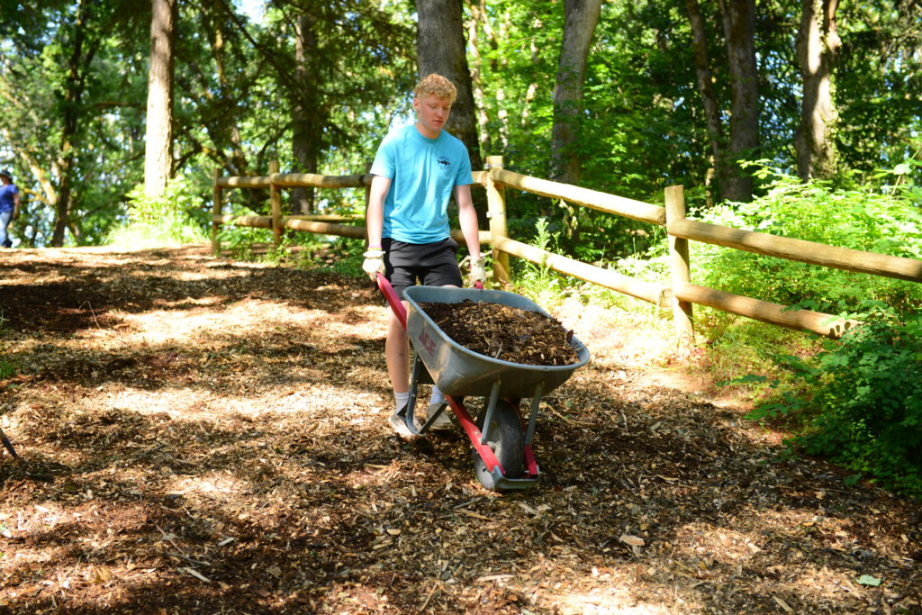 Man pushing wheelbarrow at service event