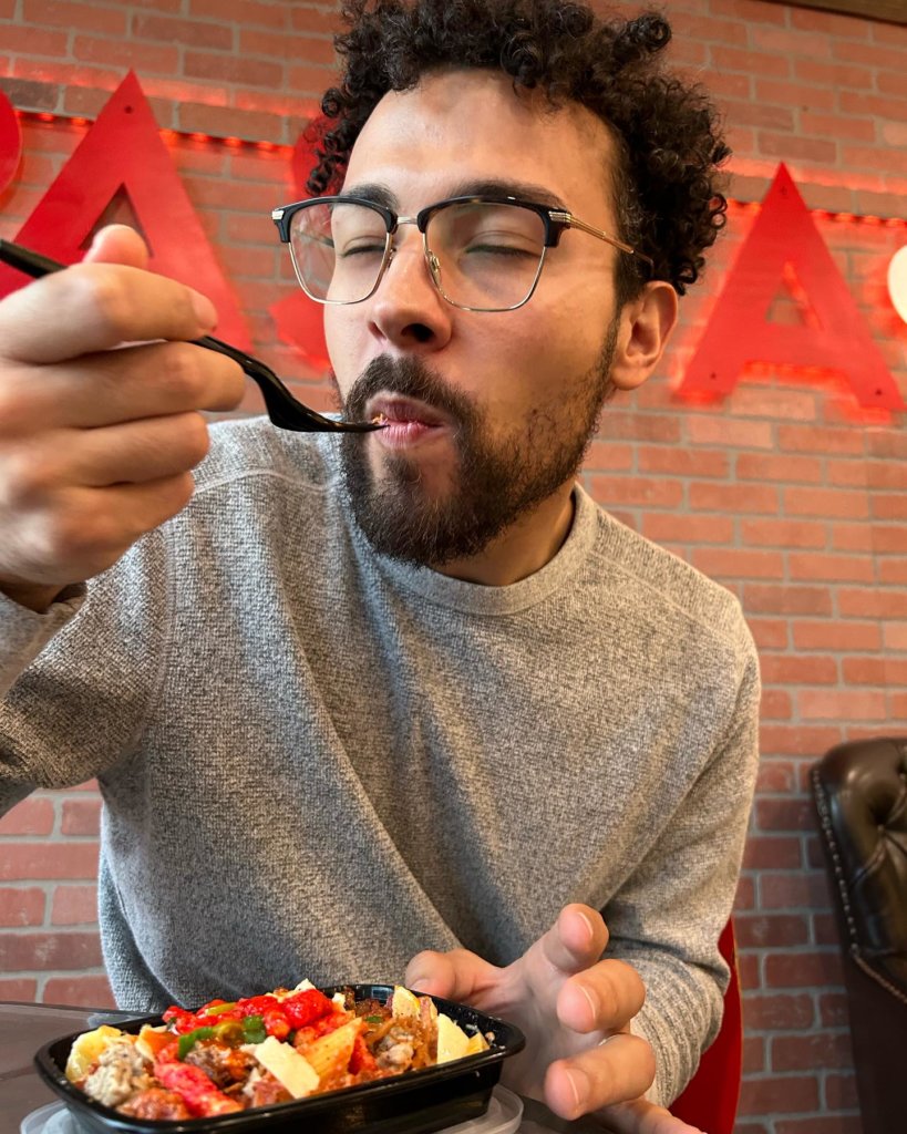 man enjoying a bowl of pasta with toppings