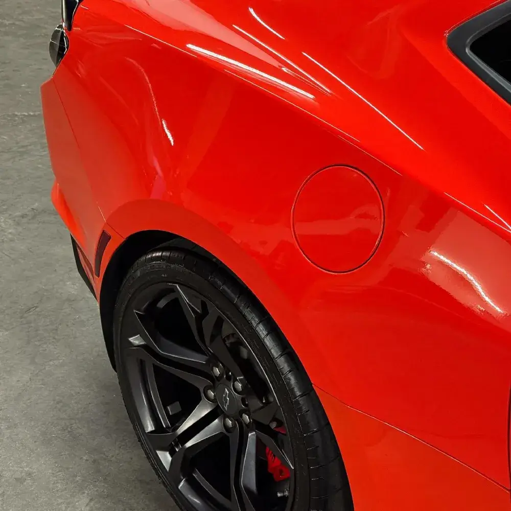 Close-up of glossy red car paint after paint correction in Tucson AZ.