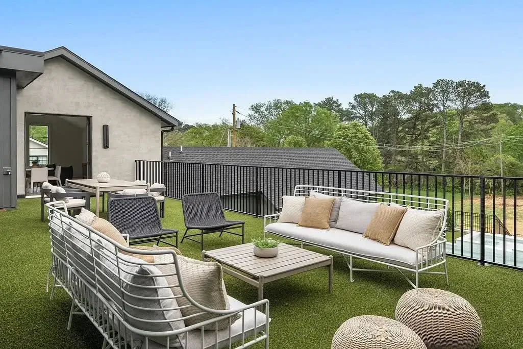 Outdoor patio lounge seating on rooftop featuring green residential turf in installation.