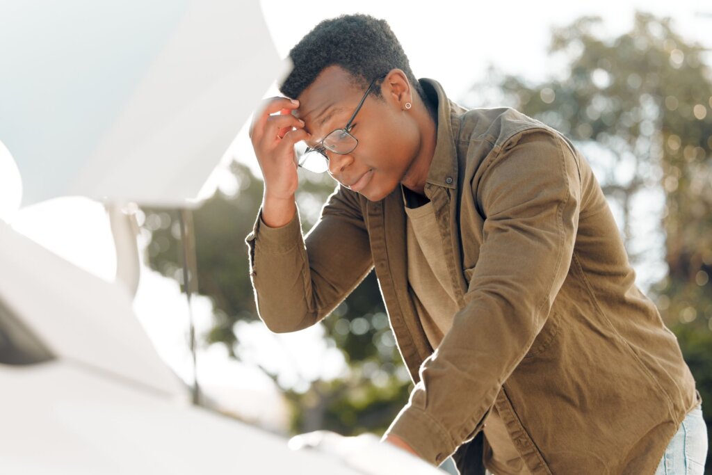 Man looking under car hood