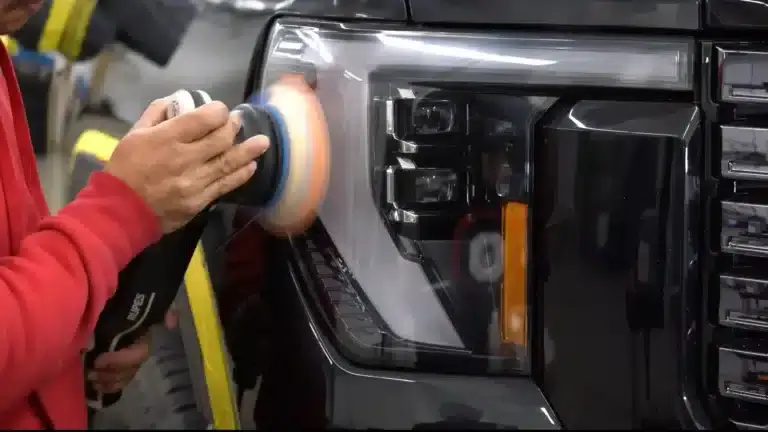 Detailer machine-buffing a truck headlight for a paint correction service in Villa Park.