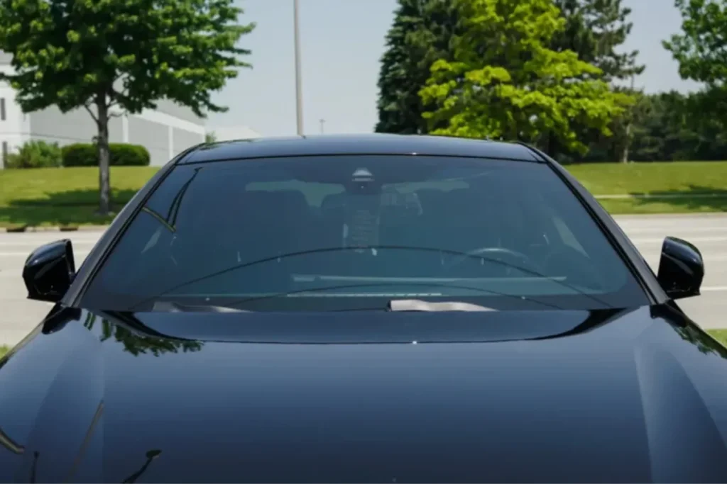 Front view of a clean windshield on a black car needing auto glass repair & replacement.
