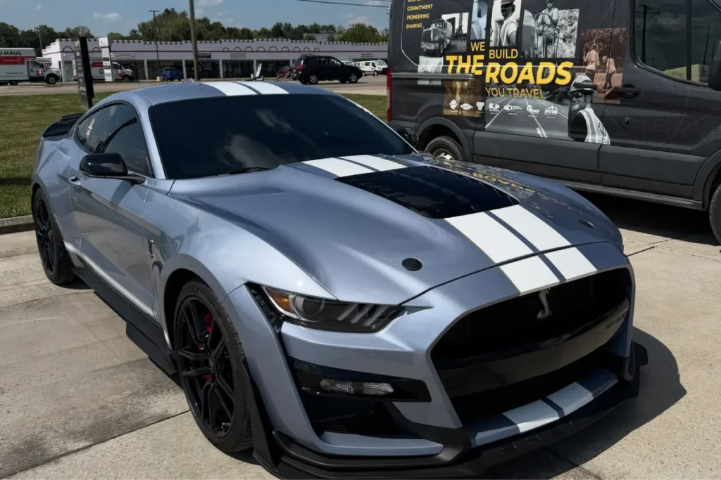 Silver sports car with white racing stripes after professional car detailing Lebanon.