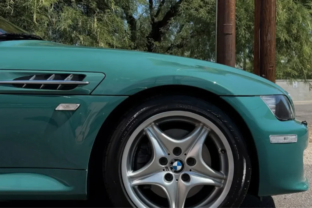 Green BMW convertible parked outside, showing shiny paint after ceramic coating in Tucson.