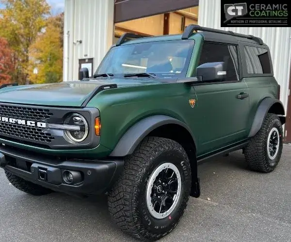 highlighting the matte green finish, grille, and front wheel