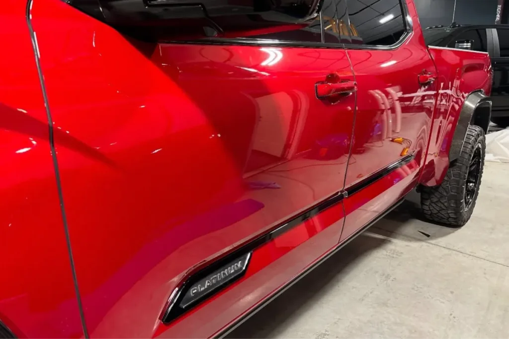 Red Toyota truck side profile showing glossy finish with paint protection film in Woodlands TX.