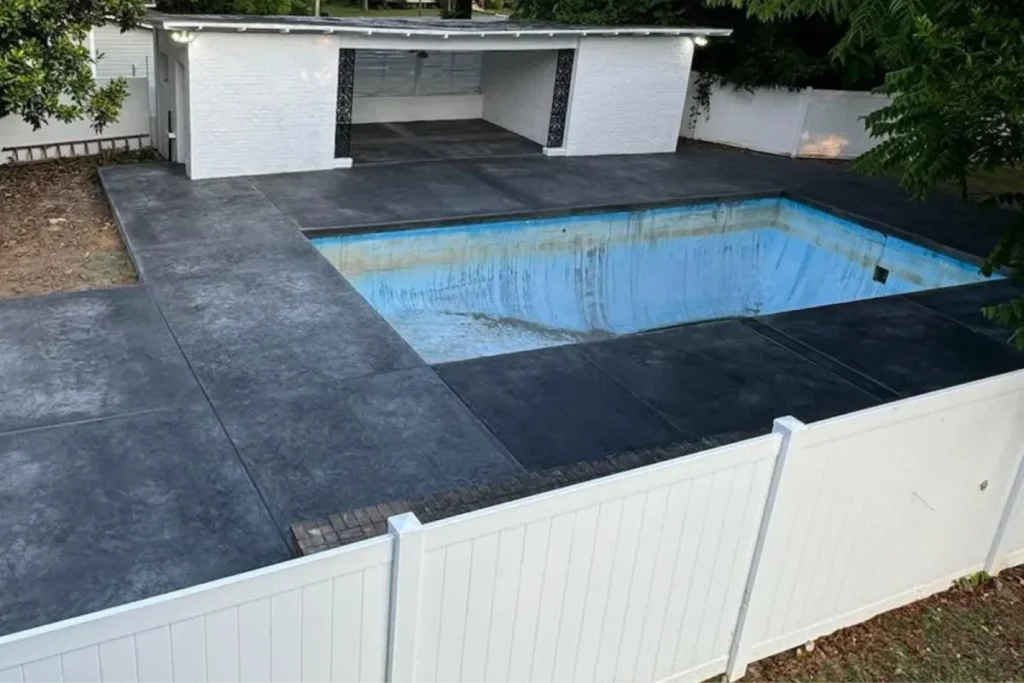 Dark stamped concrete pool deck with coping installed by pool deck contractors Murfreesboro TN.