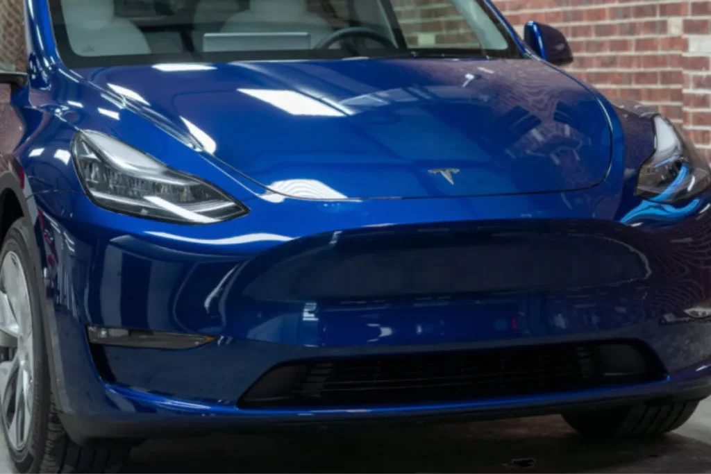 A blue Tesla Model Y in a garage, a candidate for Tesla paint protection in Houston.