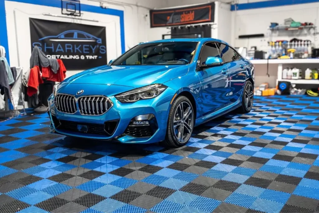 Metallic blue BMW parked in a garage after receiving vinyl wrap in Sarasota, FL.