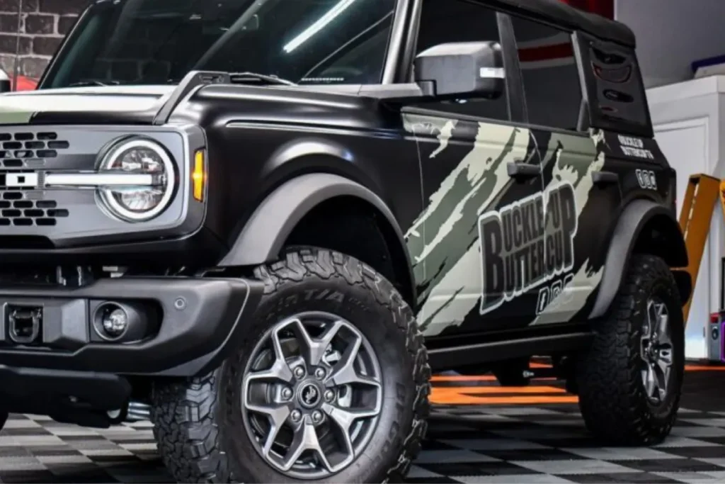 Custom graphics vinyl wrap Miami applied to a Ford Bronco inside an auto shop.