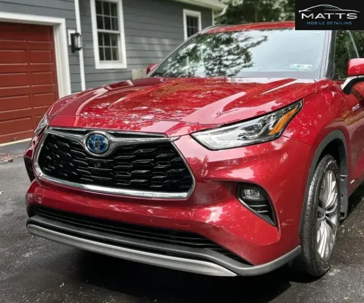 Close-up front view of a shiny red Toyota SUV showing its grille, headlights, and front bumper.